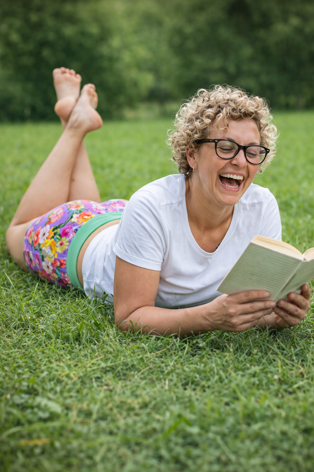 KI generiert, Frau im Baumwollpanty mit Buch in der Hand auf einer Wiese liegend